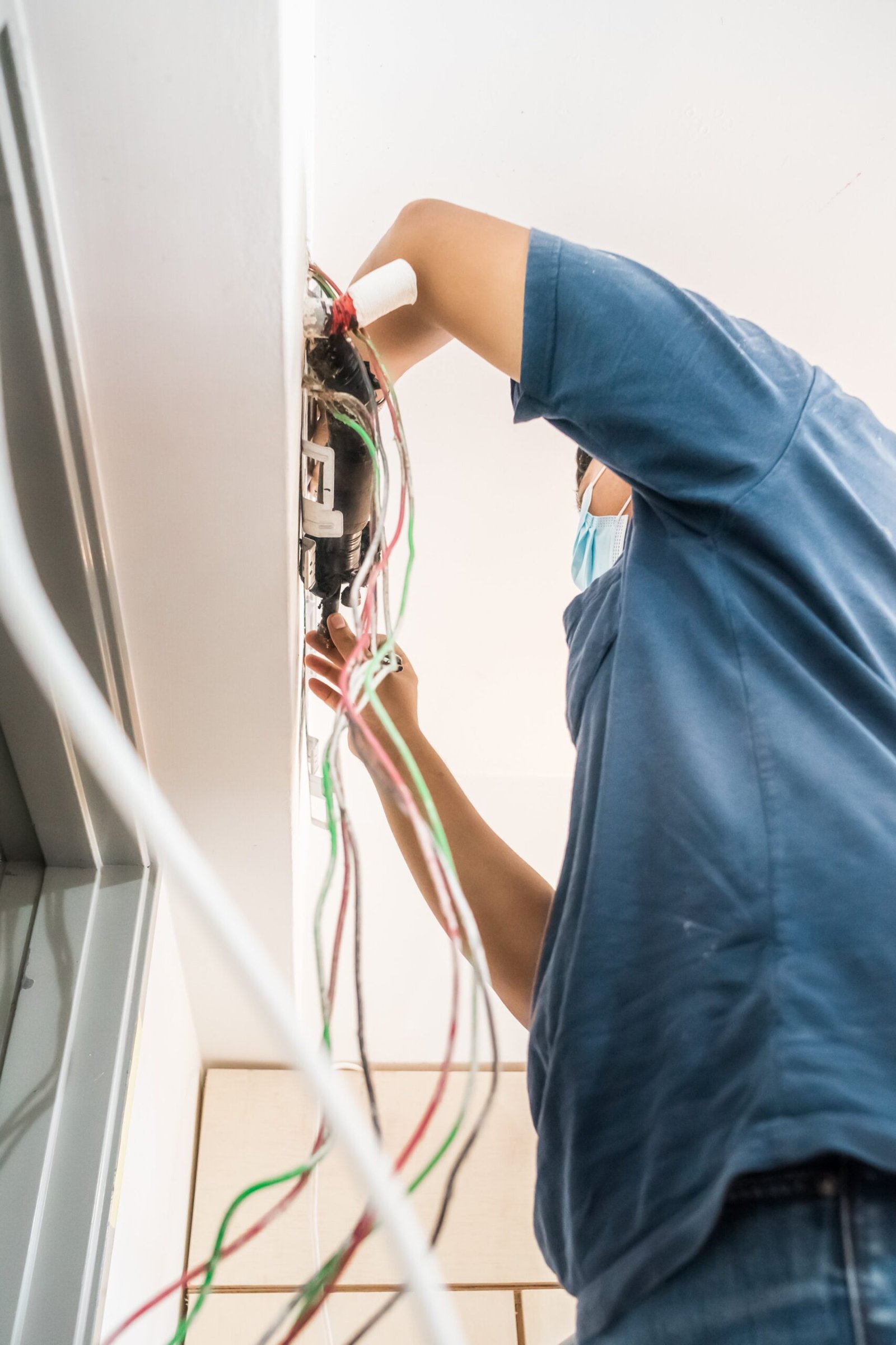 Bangi, Malaysia - Sep 28, 2021 Technician repairing air conditioner on the wall