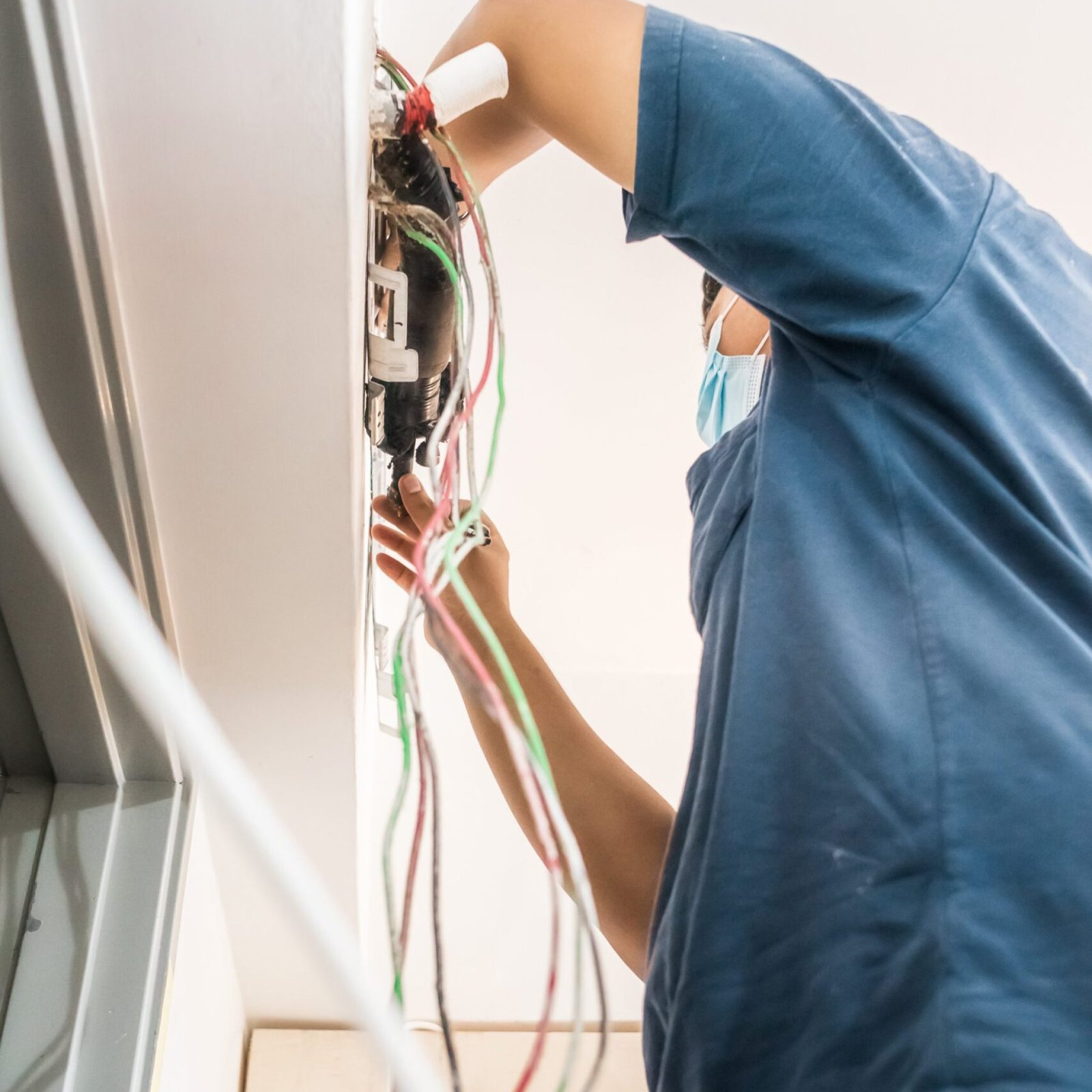 Bangi, Malaysia - Sep 28, 2021 Technician repairing air conditioner on the wall